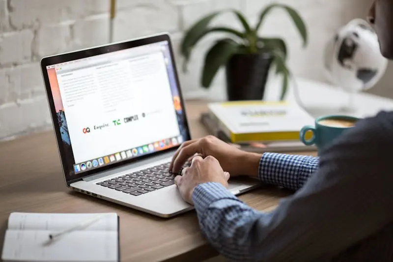 A man with a laptop working with coffee on his table