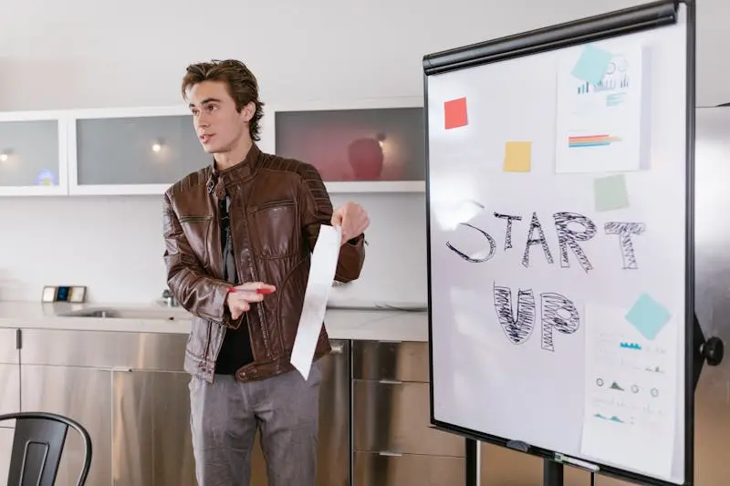 Man in leather jacket giving presentation to his team