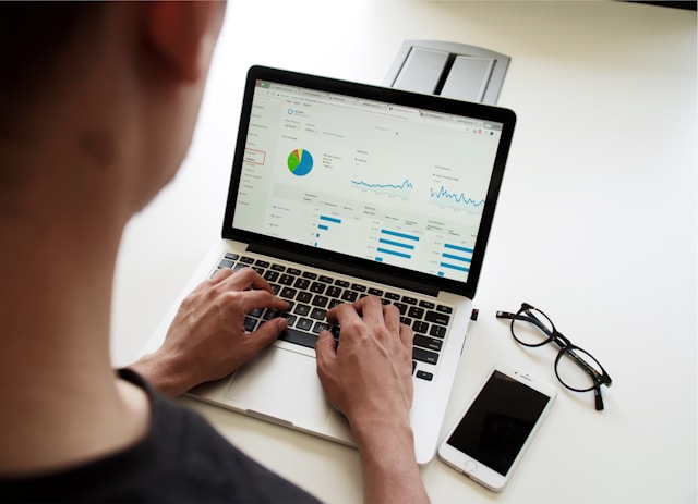 Man using a laptop, analysing reports.