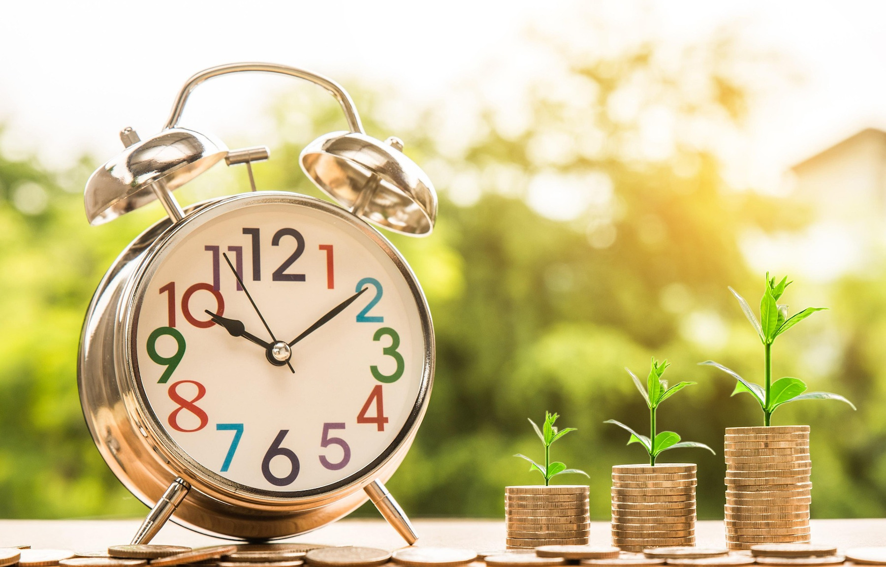 clock next to small pile of coins