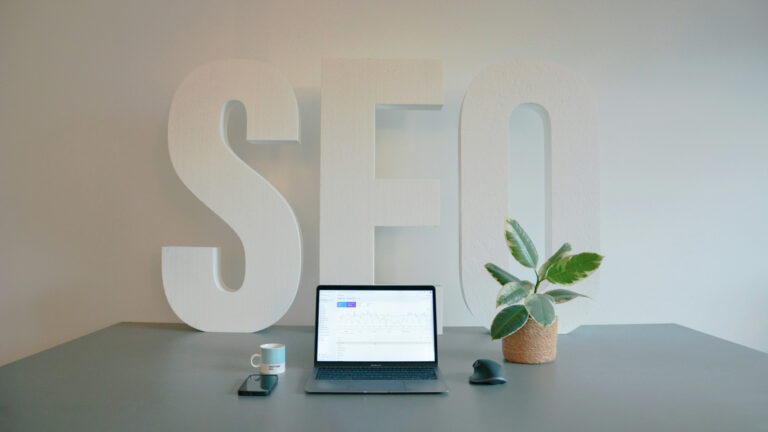 a laptop computer sitting on top of a desk with SEO sign in background